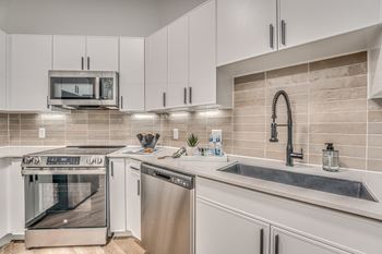 Modern kitchen with stainless steel appliances and white cabinetry